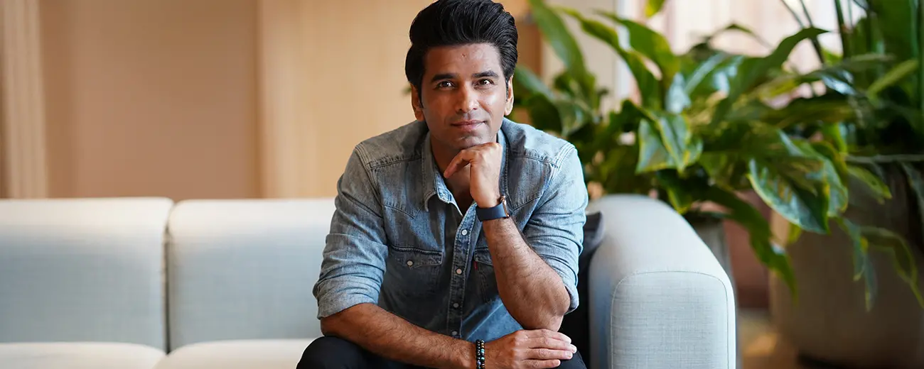 Mudasir Khan sitting on a sofa and looking into the camera.