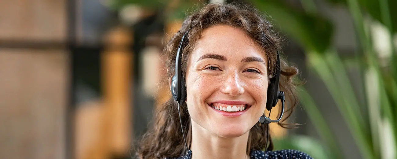 Person har ett headset på sig och ser glad ut