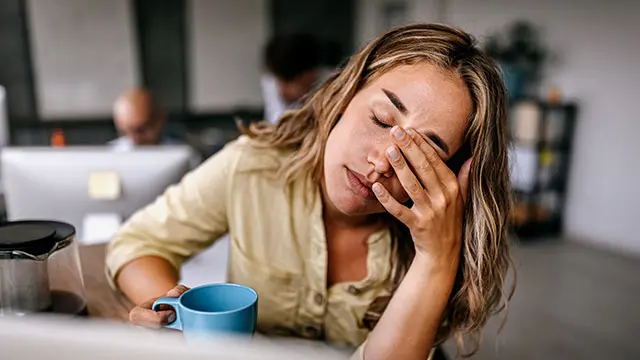 Två personer sitter vid ett bord på ett kontor och pratar med varandra