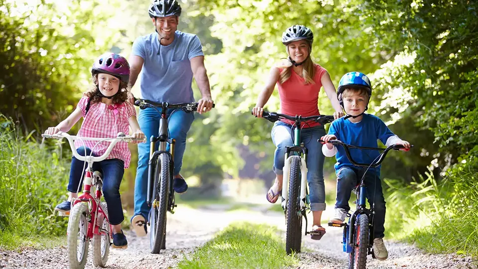 Familj som cyklar på sommaren