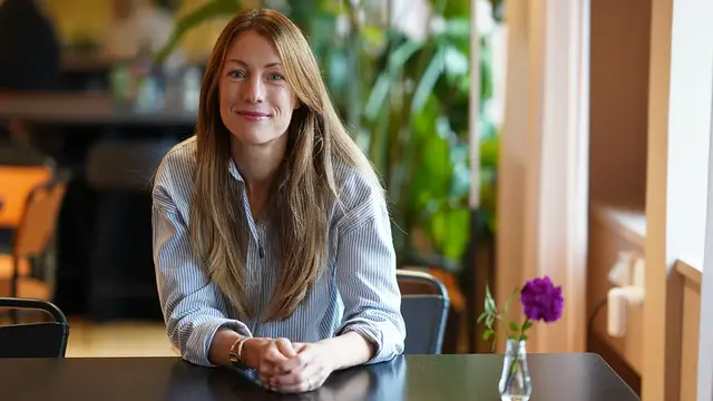 Medarbetare på Euro Accident står med kaffekopp och ler