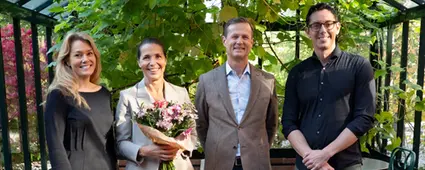 Fyra representanter från Euro Accident står med blombukett och tittar leende in i kameran